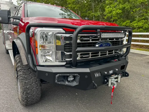 Front grille close-up showing emblem, grille slats, and mounted light bar.